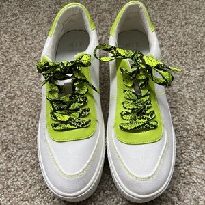 White sneaker with green and black accent. Size 8.5
